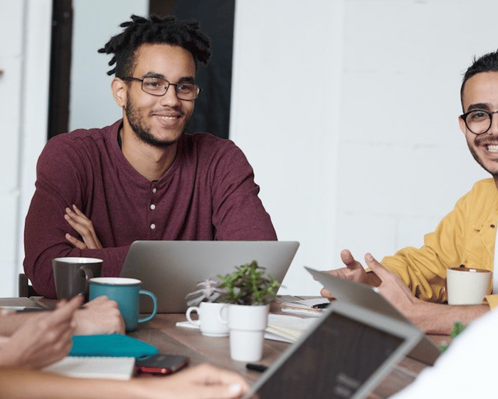 Group of diverse employees sitting around table having meeting